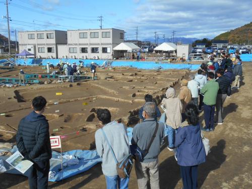 現地見学会で参加者が担当者の説明を聞く様子です(東から)