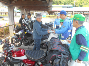 ライダーにチラシを手渡してます