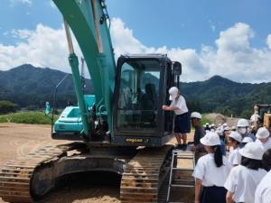 児童が重機を囲んでいる写真