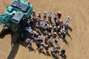 児童と重機を上空から撮影した写真