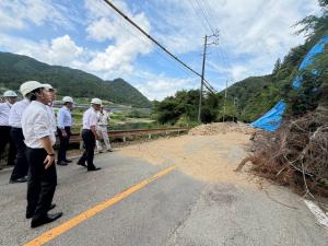 主要地方道金山明宝線の崩落現場について説明を受ける委員