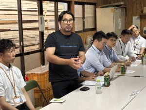 ALTERNATIVE ENERGY JAPAN株式会社において、バイオコークスについて説明を受ける委員2