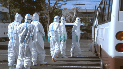 防疫措置を行うためバスに乗り込む県職員ら